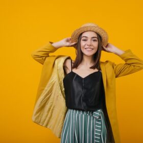 Smiling woman wearing a straw hat and black tank top